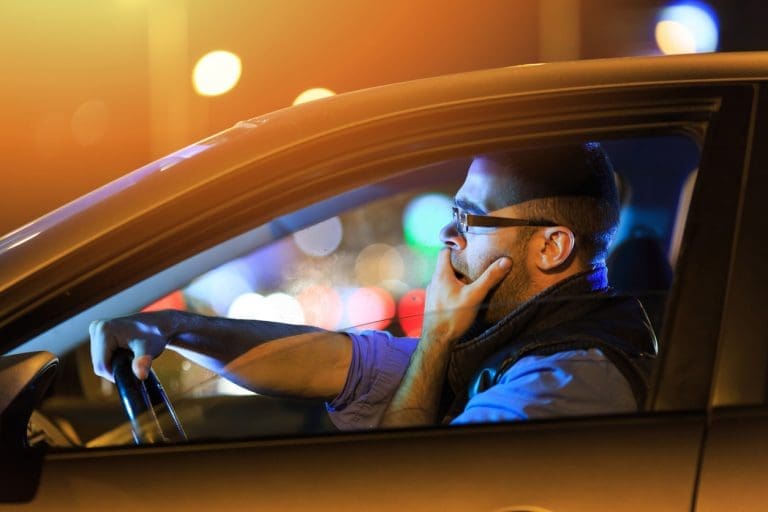 Fatigued man sitting in a car on the way to work