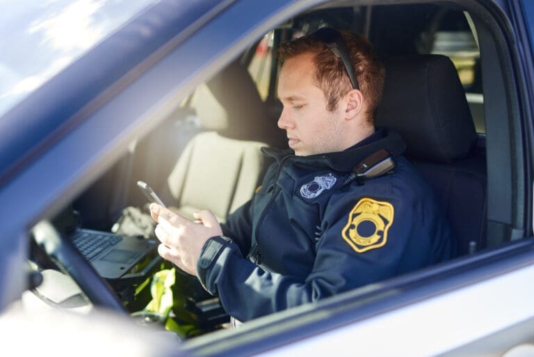 A police officer looking at scheduling software on their phone
