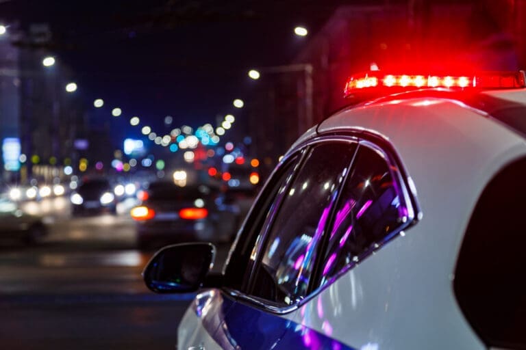 Police car at night with lights. Police Officer Hours