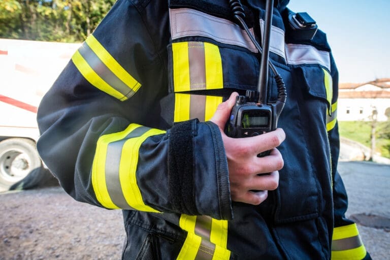 Firefighter holding a walkie talkie responding to a call