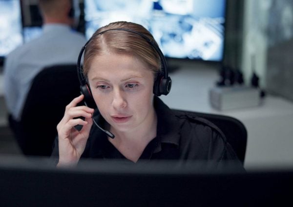 CCTV, headset and security with woman in control room for law enforcement or surveillance. Call, communication and safety with police officer at headquarters for crime, inspection or privacy.